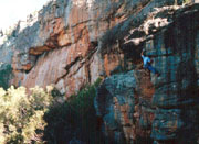 An easy route, Hyperbola, on Kitten Wall. The imposing Tjuringa Wall with super-bold routes is behind.